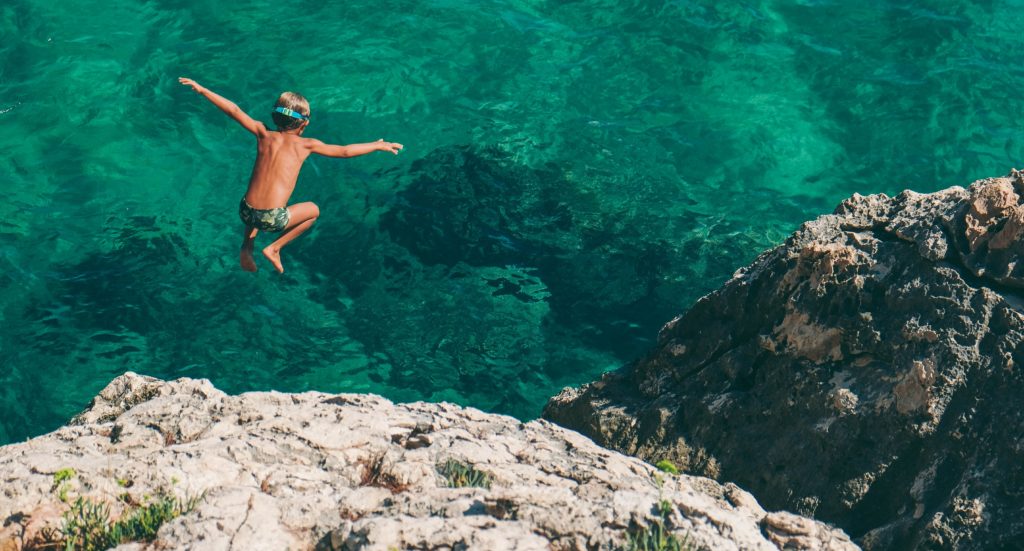 child jumping into the ocean