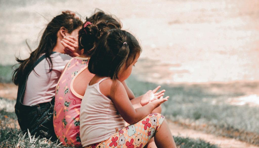 children sitting by the river